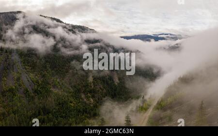 Vue panoramique aérienne du paysage montagneux à couper le souffle dans le parc provincial de Tweedsmuir (sud) dans un brouillard dense qui couvre le m environnant Banque D'Images