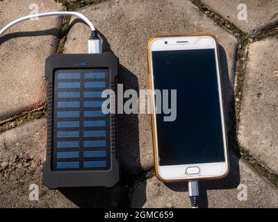 Bloc d'alimentation mobile rechargeable avec panneaux solaires, gros plan. Connecté à un téléphone portable, une tablette ou un smartphone et en charge. Banque D'Images