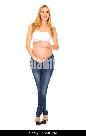 Verticale d'une femme enceinte polonaise tenant son ventre isolé sur fond blanc Banque D'Images