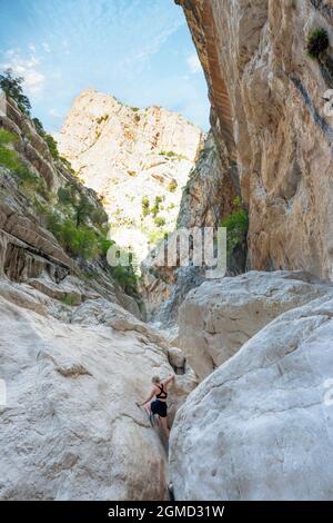 Vue imprenable sur une personne grimpant sur un rocher dans la gorge de Gorropu. Banque D'Images