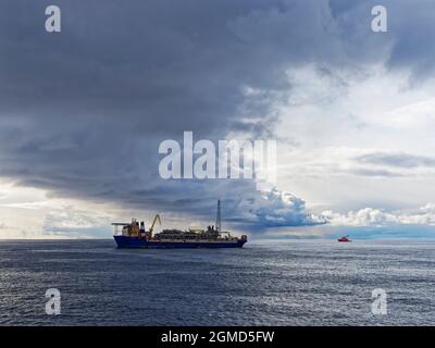 Nuages sombres formant un front de tempête au-dessus de la FPSO d'Alvheim dans le secteur norvégien de la mer du Nord au début du mois de mai. Banque D'Images