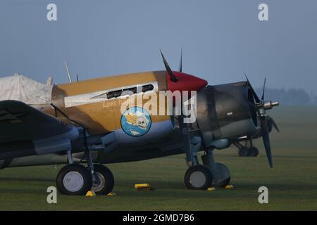 IWM Duxford, Cambridgeshire, Royaume-Uni. 18 septembre 2021. Un début malin alors que le spectacle aérien de la bataille de Grande-Bretagne aura lieu du 18-19 au 22 septembre à IWM Duxford, L'ancien site de la RAF qui a joué un rôle central dans certains des jours les plus dramatiques de l'histoire du XXe siècle - servant de base à de nombreux pilotes de Spitfire et d'ouragan pendant la Seconde Guerre mondiale. Image: The Fighter Collection Curtiss P-40F Warhawk et Curtis Hawk 75 s'assoient sur l'aérodrome brumeux au lever du soleil. Crédit : Malcolm Park/Alay Live News Banque D'Images