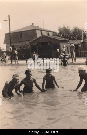 photo vintage originale d'environ 4 amis, ou de la famille des mambers qui jouent dans la mer , lac. S'amuser ensemble en été à la plage des années 1940 / vintage Banque D'Images