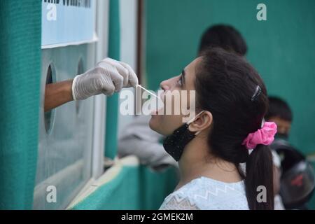 Guwahati, Inde. 18 septembre 2021. Un travailleur de la santé prélève un échantillon d'écouvillon auprès d'une femme pour les tests COVID-19 dans la ville de Guwahati, dans l'État d'Assam, dans le nord-est de l'Inde, le 18 septembre 2021. Le nombre de cas de COVID-19 en Inde est passé à 33,417,390 samedi, alors que 35,662 nouveaux cas ont été enregistrés au cours des 24 dernières heures dans tout le pays, ce qui montre les dernières données du ministère fédéral de la Santé. Credit: STR/Xinhua/Alay Live News Banque D'Images