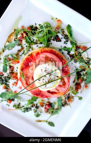 Tarte aux tomates avec fromage de chèvre et salade verte Banque D'Images