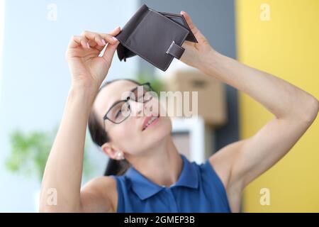 Jeune femme avec des lunettes, porte-monnaie vide à la maison Banque D'Images