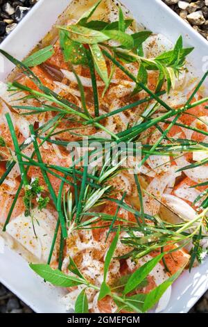 Fond de poisson cru et divers ingrédients dans un plat Banque D'Images