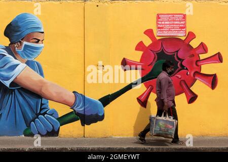 Chennai, Tamil Nadu, Inde. 18 septembre 2021. Un homme passe devant une fresque de sensibilisation au coronavirus Covid-19 le long du bord de la route à Chennai. (Image de crédit : © Sri Loganathan/ZUMA Press Wire) Banque D'Images