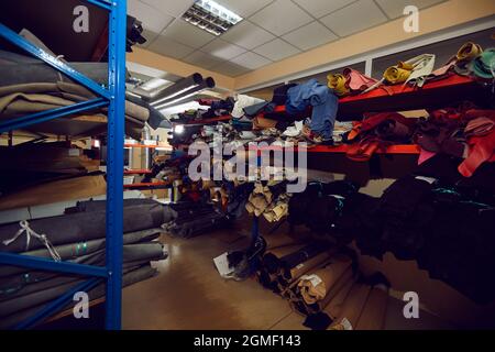 Rangées de tablettes de rangement pleines de rouleaux en tissu et en cuir à l'usine de chaussures ou de vêtements Banque D'Images