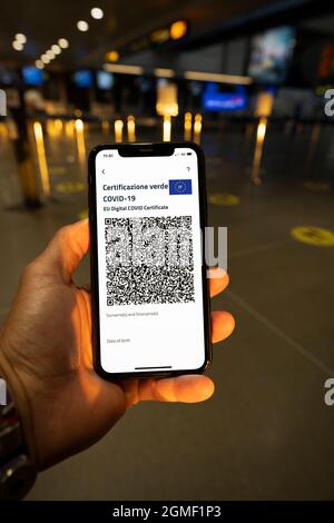 Vue aérienne d'une personne qui tient un smartphone avec le Digital Green Pass dans un terminal d'aéroport. Concept de voyage pendant le Covid-19 Banque D'Images