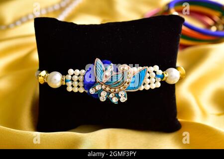 Magnifique rakhi avec Rali chawal sur tissu de soie dorée Banque D'Images