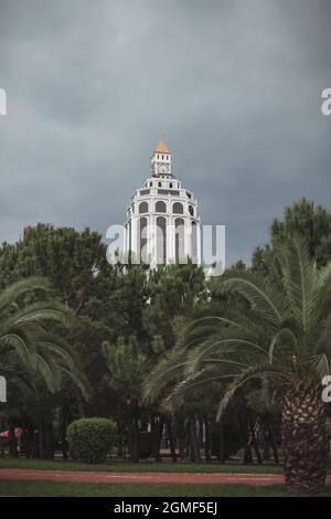 Bâtiment haut de conception moderne à Batumi, Géorgie. Gratte-ciel avec un design intéressant derrière les palmiers. Photo de haute qualité. Banque D'Images