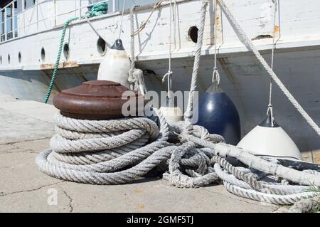 De vieilles cordes nautiques attachées sur le bollard et des bouées assurant la sécurité d'un vieux navire abandonné rouillé, à Zadar, Croatie Banque D'Images