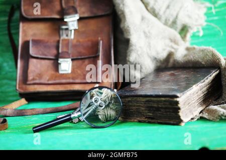 Vieux sac en cuir avec une loupe sur une table en bois brun voyageur espace de copie de fond. Banque D'Images