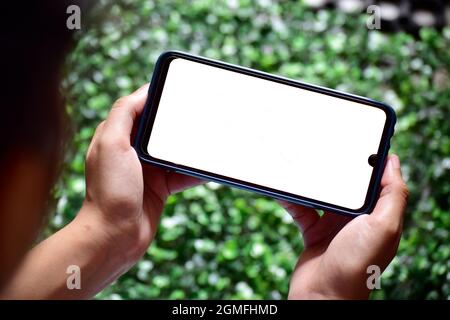 main tenant le smartphone, mouvement de jeu Banque D'Images