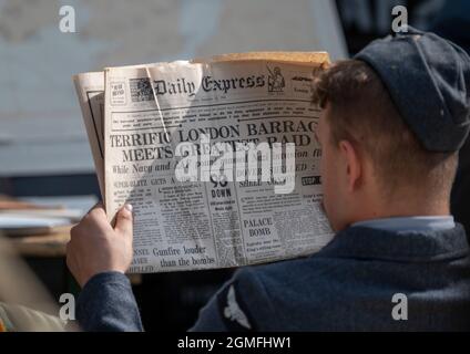 IWM Duxford, Cambridgeshire, Royaume-Uni. 18 septembre 2021. Le spectacle aérien de la bataille d'Angleterre aura lieu du 18-19 au 22 septembre au Musée impérial de la guerre IWM Duxford, L'ancien site de la RAF qui a joué un rôle central dans certains des jours les plus dramatiques de l'histoire du XXe siècle - servant de base à de nombreux pilotes de Spitfire et d'ouragan pendant la Seconde Guerre mondiale - avec le spectacle aérien mettant en vedette des acteurs fatigués des années 1940. Un pilote de la RAF dans l'uniforme de la WW2 lit les nouvelles de la première page sur le journal Daity Express daté de septembre 12 1940. Crédit : Malcolm Park/Alay Live News Banque D'Images