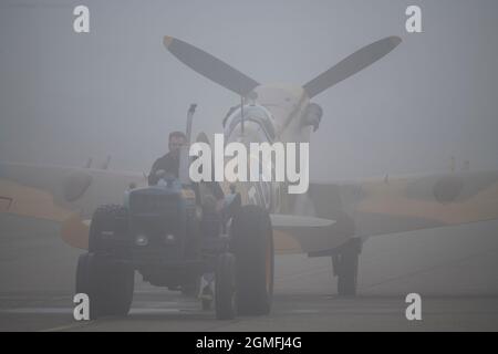 IWM Duxford, Cambridgeshire, Royaume-Uni. 18 septembre 2021. Un début malin alors que le spectacle aérien de la bataille de Grande-Bretagne aura lieu du 18-19 au 22 septembre à IWM Duxford, L'ancien site de la RAF qui a joué un rôle central dans certains des jours les plus dramatiques de l'histoire du XXe siècle - servant de base à de nombreux pilotes de Spitfire et d'ouragan pendant la Seconde Guerre mondiale. Image: Comanche Fighters Supermarine Spitfire Mk VC remorqué le long de la voie de circulation dans une brume matinale intense. Crédit : Malcolm Park/Alay Live News Banque D'Images