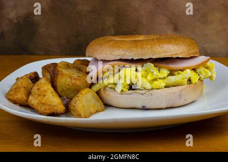 dessus d'œuf sablée avec du bacon canadien sur un bagel aux baies bleues . Banque D'Images