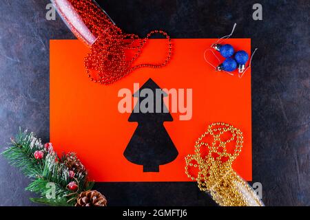Verres à champagne avec perles de Noël sur fond sombre. Boules de Noël, perles multicolores et branche d'épinette. Arbre de noël en papier. Vue de dessus Banque D'Images