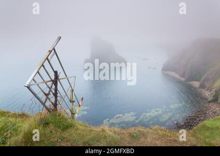 Vieille porte tombant du bord de la falaise à Duncansby Head et piles de mer, à proximité de John O Groats, Caithness, nord-est de l'Écosse avec un fret de mer. Banque D'Images