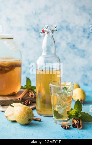 Suraliment de kombucha non alcogolique ou alcoolique, fermenté et cru. Thé glacé avec probiotique naturel sain dans le verre avec menthe sur fond bleu Banque D'Images