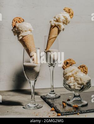 Des cônes de glace à la vanille dans des verres à vin avec des biscuits aux pépites de chocolat Banque D'Images