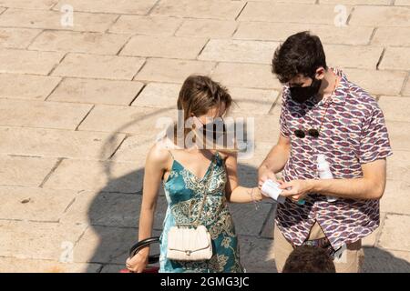 Prvic Luka, Croatie - 25 août 2021 : jeune couple portant un masque facial, tenant des billets de bateau et des désinfectants pour les mains attendant sur un quai pour embarquer sur un bateau Banque D'Images
