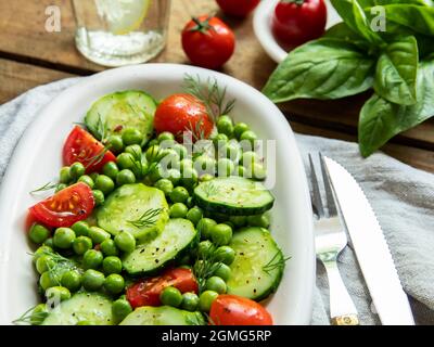 Salade. Salade de légumes frais avec tomate, concombre, basilic, pois verts. Banque D'Images