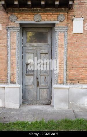 Portes anciennes de l'entrée principale de la maison, avec moulures sur la façade et un panneau sans numéro Banque D'Images