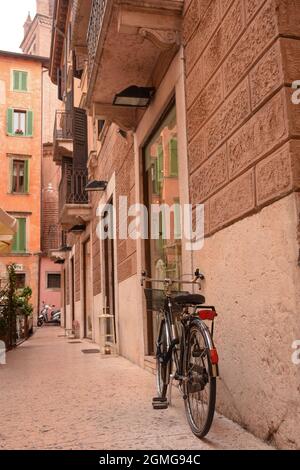 Près de l'entrée de la vieille maison, dans le vieux quartier de la ville, il y a un vélo avec un panier pour transporter des provisions près du mur. Banque D'Images