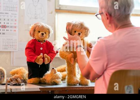 Coburg, Allemagne. 16 septembre 2021. L'ouvrier qualifié de jouet Ina Kniewe coupe les cheveux de la peluche Merkel. L'usine de teddy Hermann de Coburg a bourré des ours dans sa gamme qui rappellent le roi Ludwig, B. Obama ou la reine du Royaume-Uni - maintenant Angela Merkel a également été ajoutée. Avec sa perruque, ses vêtements, sa "chaîne allemande" et son "rhombus erkel", l'ours en peluche rappelle le chancelier allemand. Credit: Nicolas Armer/dpa/Alay Live News Banque D'Images