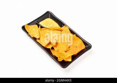 Puces Nacho avec moustard trempant dans une plaque isolée sur fond blanc avec masque de découpe Banque D'Images