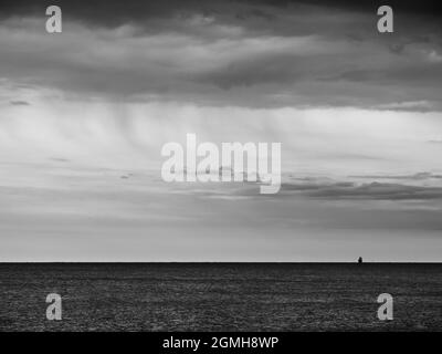 Mer Adriatique Océan Horizon avec Silhouette de cargo à Grado, Italie en noir et blanc monochrome Banque D'Images