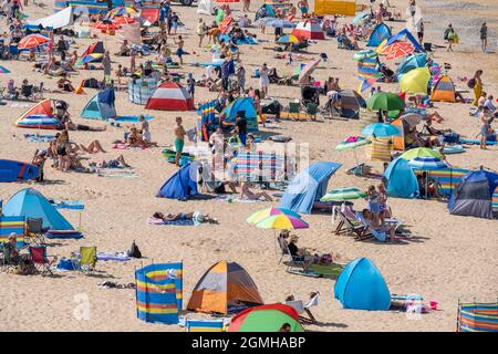 La chaleur intense et le soleil permanent font sortir la foule des vacanciers sur la plage de Fistral à Newquay, dans les Cornouailles. Banque D'Images