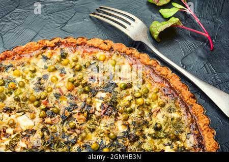 Tarte fraîche avec verger, fromage feta et pois verts. Tarte aux herbes, bonne nutrition. Banque D'Images