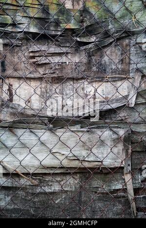 Composition texturale de contreplaqué altéré et de clôture en chaînette rouillée sur le sentier du patrimoine de Ping Shan, New Territories, Hong Kong Banque D'Images