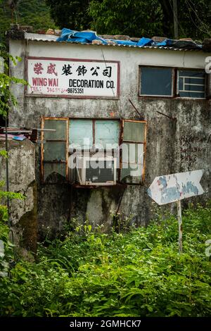 Signe ironique annonçant une entreprise de décoration sur une maison en ruine dans le village de NIM Shue WAN, île Lantau, Hong Kong Banque D'Images