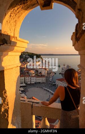 Une touriste floue regardant le beau coucher de soleil dans la tour Piran Zvonik Campanile Bell Tower . Banque D'Images