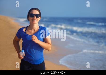 portrait d'une femme heureuse qui court sur la plage Banque D'Images