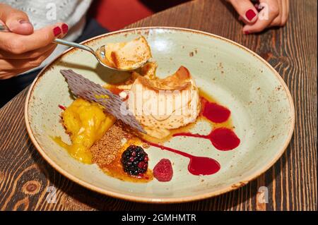 Flan aux œufs avec crème glacée, chocolat et baies rouges Banque D'Images