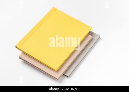 Pile de livres à couverture rigide multicolore sur fond blanc Banque D'Images