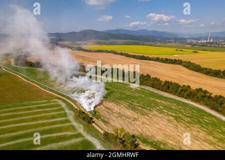 Vue aérienne d'un tracteur qui répand de la chaux sur les champs agricoles pour améliorer la qualité du sol après la récolte d'automne. L'utilisation de poudre de chaux pour neutraliser Banque D'Images