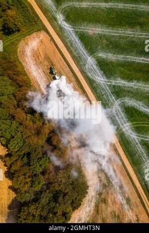 Vue aérienne d'un tracteur qui répand de la chaux sur les champs agricoles pour améliorer la qualité du sol après la récolte d'automne. L'utilisation de poudre de chaux pour neutraliser Banque D'Images