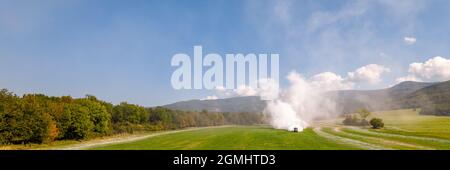 Vue aérienne d'un tracteur qui répand de la chaux sur les champs agricoles pour améliorer la qualité du sol après la récolte d'automne. L'utilisation de poudre de chaux pour neutraliser Banque D'Images