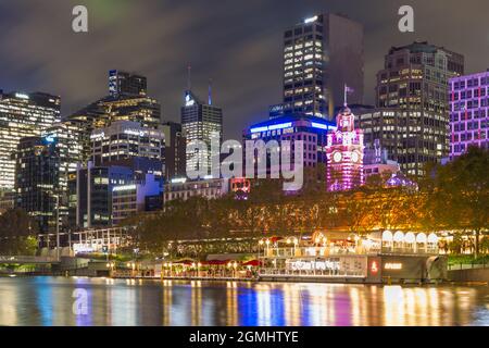 La ville de Melbourne, en Australie, vue de nuit depuis la Yarra River, en regardant vers les gratte-ciel de la ville et le bar-restaurant 'Arbory afloat' au bord de l'eau. Banque D'Images