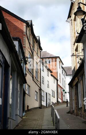 Maisons sur la colline escarpée de High Street, Knighton, Powys, pays de Galles, Royaume-Uni. Une main courante s'étend jusqu'au centre de la rue Banque D'Images