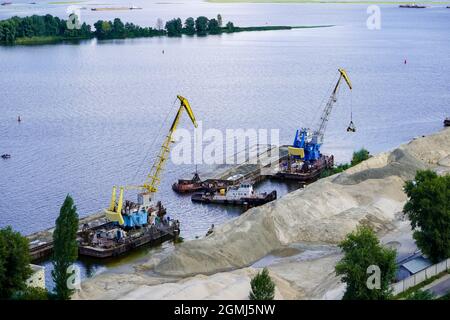 Port de la rivière . Chargement du sable sur une barge. Drainage des rives du Dnieper. Banque D'Images