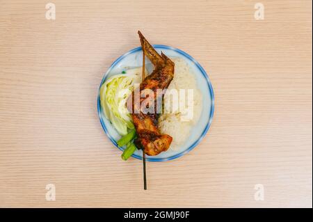 isolez le plat de cuisse de poulet grillée et le pilon sur une table en bois Banque D'Images