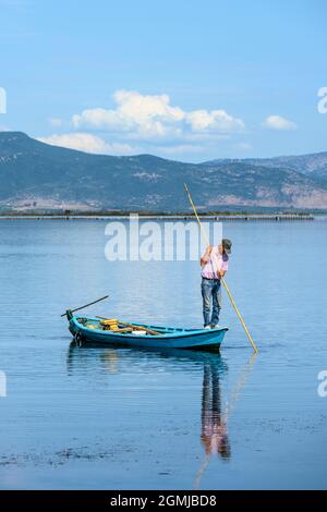 Pêcheur, pêche à la lance dans le lagon de Tsoukaliou au parc environnemental de Salaora, dans le golfe Ambracien, dans la municipalité d'Arta, Epirus, Grèce. Banque D'Images