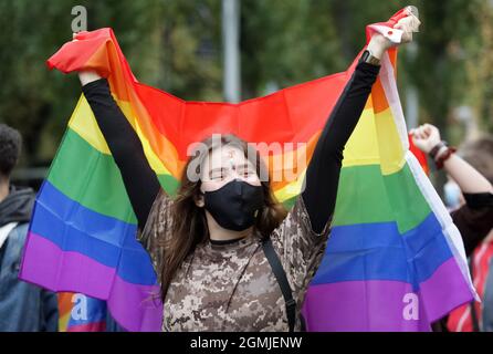 Une femme portant un masque facial porte un drapeau arc-en-ciel pendant la Marche pour l'égalité KyivPride 2021 de la communauté LGBT.des milliers de participants se sont produits à Kiev pour le défilé annuel de la gay Pride ou la Marche pour l'égalité. Banque D'Images